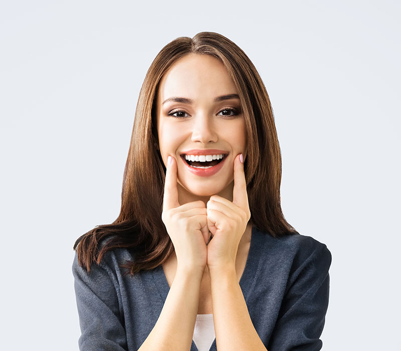 Conservativa e ricostruzioni dentali Ragazza che sorride indicando il sorriso