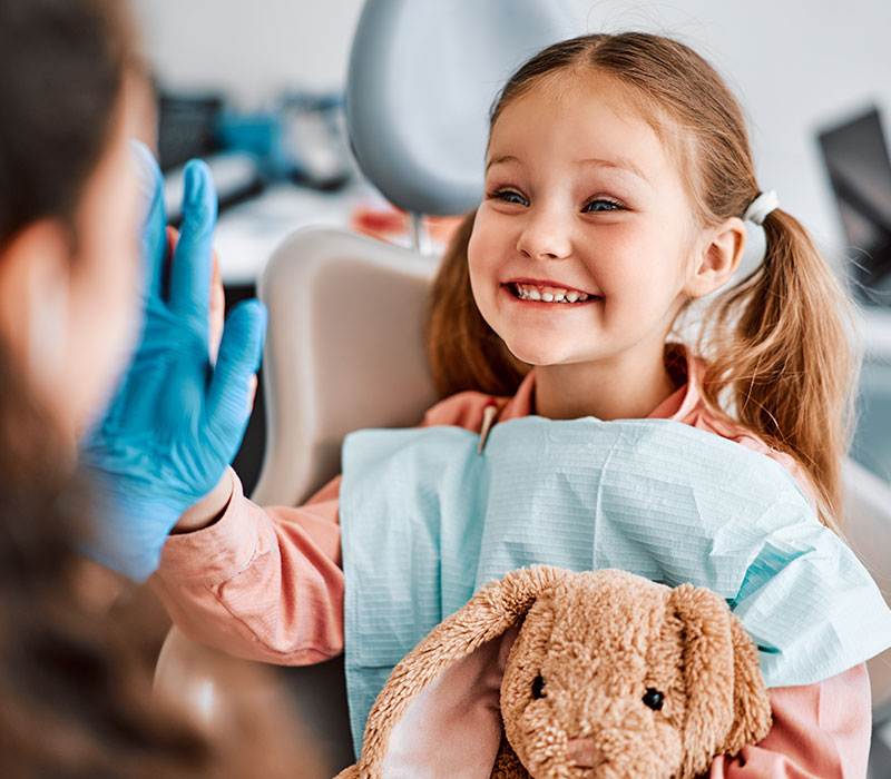 Odontoiatria pediatrica Bambina sorride con il dentista
